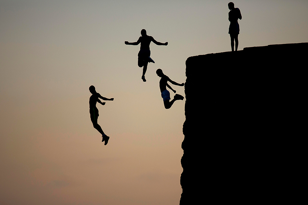 Kids jump into the Mediterranean in Akko (Photo: AP)