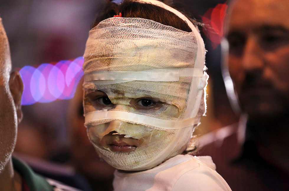 אסל אחמד, בת ארבע, נישאת על-ידי אביה אחרי פיגוע בקרדה, עיראק (צילום: AP) (צילום: AP)