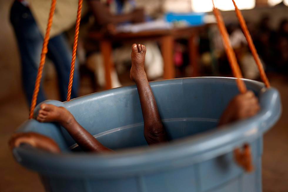 שוקלים ילד בדלי ברפובליקה של מרכז אפריקה. כחצי מתושבי המדינה הענייה סובלים מרעב (צילום: AP) (צילום: AP)