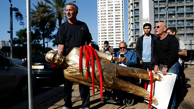 People carry out the statue (Photo: EPA)