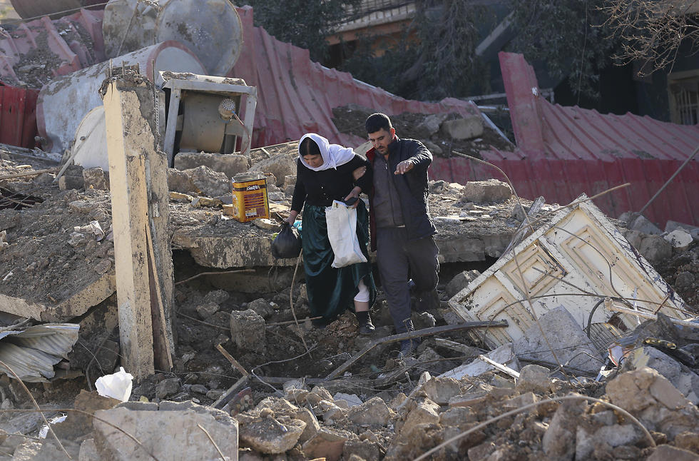 משפחה יזידית בוחנת את הנזק לביתה, מזרחית למוסל (צילום: AP) (צילום: AP)