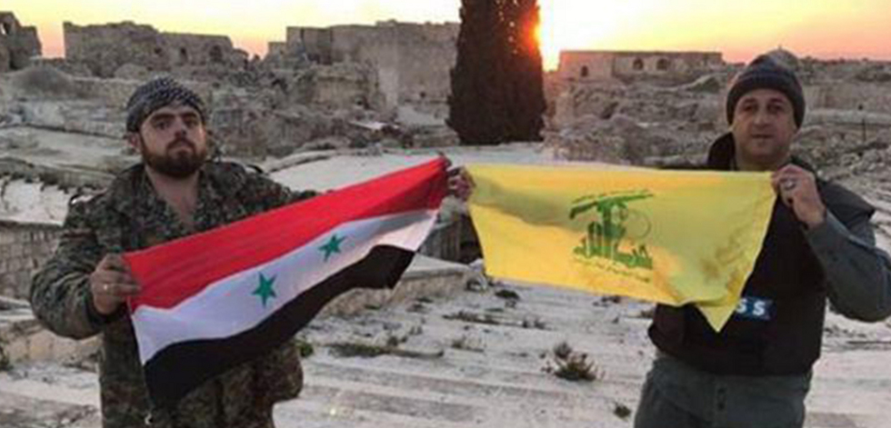 A Hezbollah banner alongside the Syrian flag in Syria
