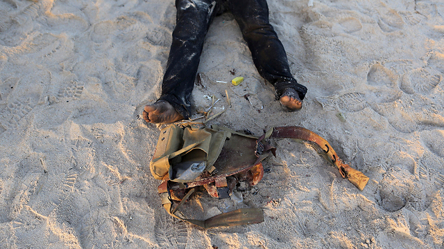 מאבטח הרוג על חוף הים ואפודו לצדו, לאחר מתקפת ג'יהאדיסטים בחוף השנהב (צילום: רויטרס) (צילום: רויטרס)