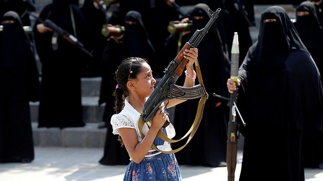 ילדה מניפה נשק בצעדת נשים תומכות המורדים השיעים בתימן (צילום: רויטרס) (צילום: רויטרס)