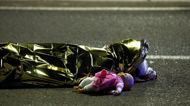 גופת אחד ההרוגים ובובת ילדה בצדה אחרי פיגוע הדריסה בניס, צרפת, ביום הבסטיליה. 85 בני אדם נרצחו בו ועוד עשרות נפצעו קשה (צילום: רויטרס) (צילום: רויטרס)