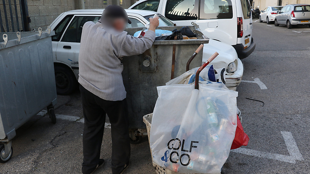 Homeless Israeli looks for food in the trash (Photo: Shaul Golan)