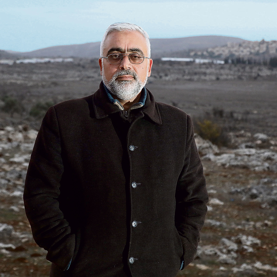 Hazem Hassim Ajaj against the backdrop of Amona. ‘I don’t want any compensation. Money comes and goes, but the land stays’ (Photo: Shaul Golan)