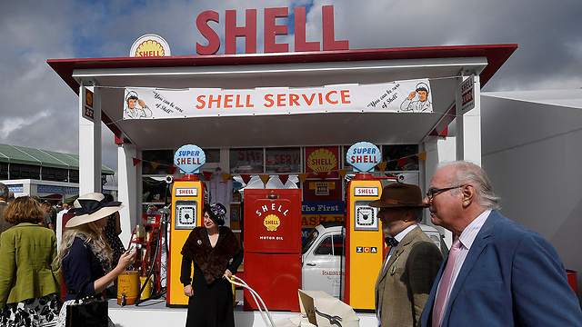 מבקרים וחובבי מכוניות מול תחנת דלק של Shell ששופצה, צופים בפסטיבל GoodWood Revival - אירוע שנתי שבו חוגגים את ימי השיא של מרוץ מכוניות ואופנועים מאמצע המאה ה-20 (צילום: רויטרס) (צילום: רויטרס)
