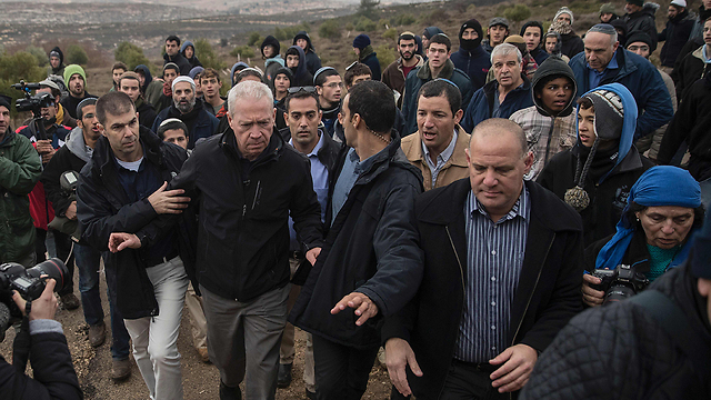 Galant surrounded by activists in Amona (Photo: AFP)