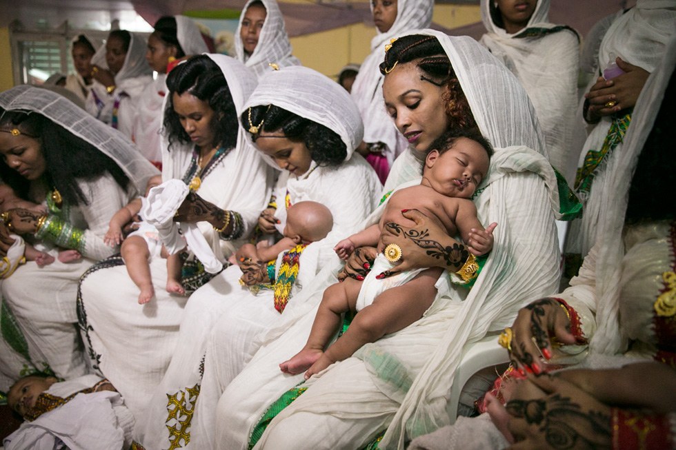 התמונה שזכתה בפרס: נשים מהקהילה האריתראית מכינות את תינוקותיהן לטקס הטבלה בכנסייה בדרום תל אביב (צילום: אלעד מלכה)