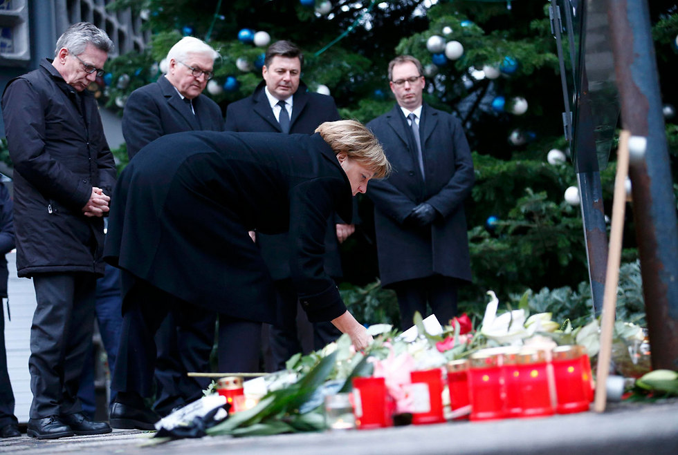 Angela Merkel lays flowers in memory of those killed (Photo: Reuters)