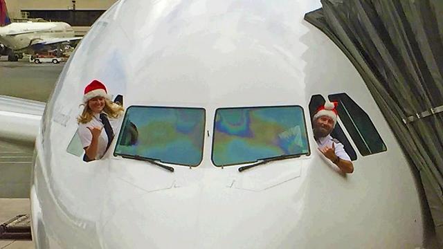צוות הוואיאן איירליינס מפגין רוח חג דרך חלונות המטוס ()