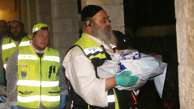 מפקד זק"א ירושלים בנצי אוירינג נושא את גופת הבת הקטנה (צילום: אלכב קולומויסקי) (צילום: אלכב קולומויסקי)
