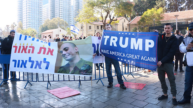 Protesters with a sign with Elor's picture saying 'Giving the light back to Elor' alongside a Trump support sign (Photo: Dana Kopel)