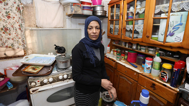 נג'אח עוואד במטבח הדירה שבה היא חיה במחנה הפליטים שתילא (צילום: AFP) (צילום: AFP)