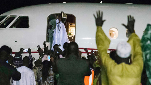 תומכיו של ג'אמה מריעים לו בעזבו את גמביה, אמש (צילום: AFP) (צילום: AFP)