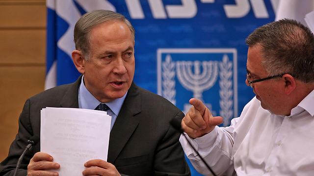 Netanyahu at a Likud party meeting with coalition chairman MK David Bitan (File photo: AFP)