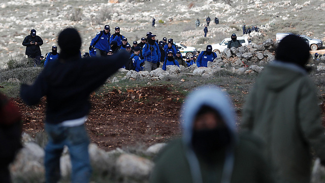Angry residents face policemen in Amona (Photo: AFP)