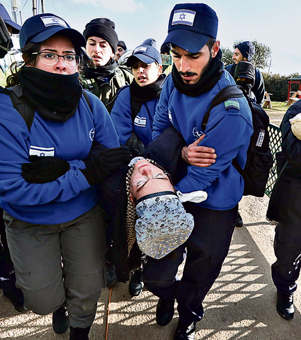 The woman being carried away (Photo: Shaul Golan)