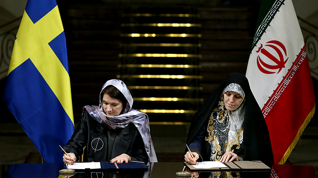 לינד (משמאל) חותמת על הסכמים עם איראן בשבוע שעבר (צילום: AP) (צילום: AP)