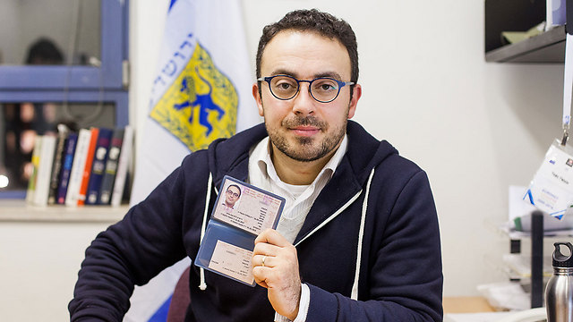 Mark Halawa, holding his temporary resident certificate (Photo: Daniel Elior) (Photo: Daniel Elior)