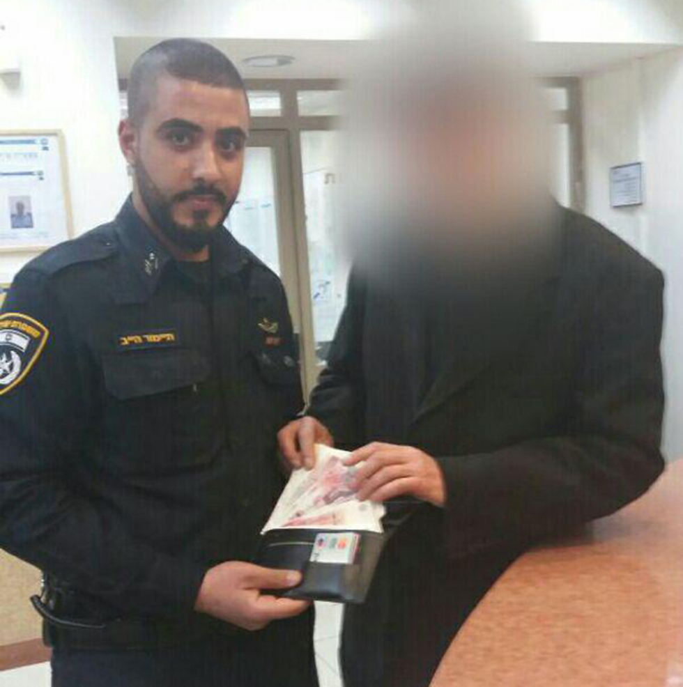 בעליו של המזוודה מקבל מהשוטר את כספו בחזרה (צילום: משטרת ישראל) (צילום: משטרת ישראל)