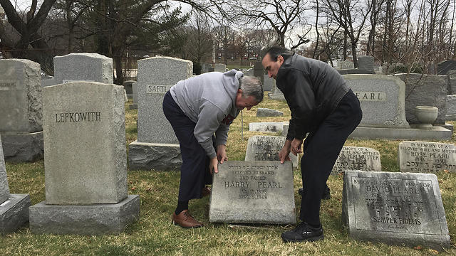Philadelphia Mayor Jim Kenney (L) helps David Pearl Jr. lift up the headstone of Pearl's grandfather (Photo: AP)