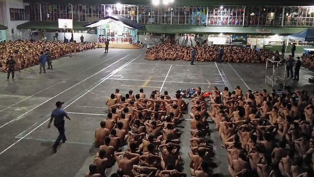 אסירים בפיליפינים לפני חיפוש סמים על גופם (צילום: AFP) (צילום: AFP)