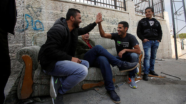 Yassin holds the hand of a Palestinian man as he is filmed in Aida refugee camp (Photo: Reuters)
