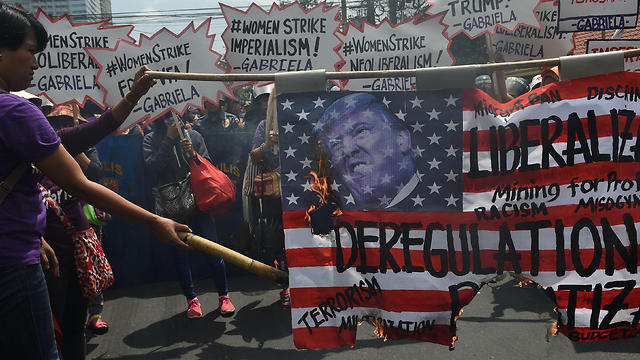 שורפים דגל אמריקני עם תמונת טראמפ בפיליפינים (צילום: AFP) (צילום: AFP)