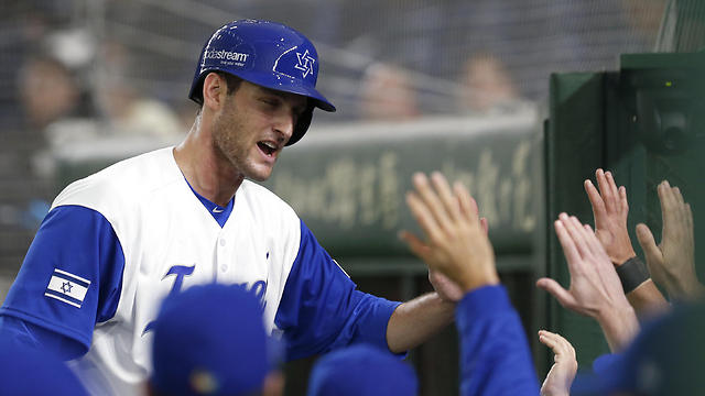 Israel's Nate Freiman is celebrated by teammates at dugout after scoring on Blake Gailen's double off Cuba's pitcher Jose Angel Garcia during the sixth inning of their second round game (Photo: AP)