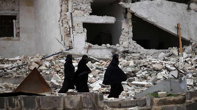 מדינה הרוסה. נשים סוריות הולכות בין ההריסות בעיר אל-באב (צילום: רויטרס) (צילום: רויטרס)
