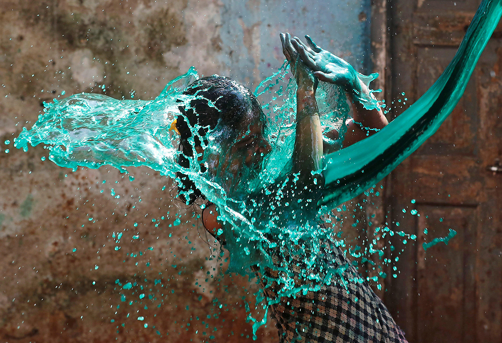 ילדה הודית חוטפת מקלחת של צבע במהלך חגיגות פסטיבל הולי במומבאי (צילום: רויטרס) (צילום: רויטרס)