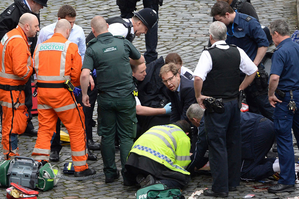 חבר הפרלמנט טוביאס אלווד מנסה להציל את חייו של השוטר (צילום: AP) (צילום: AP)