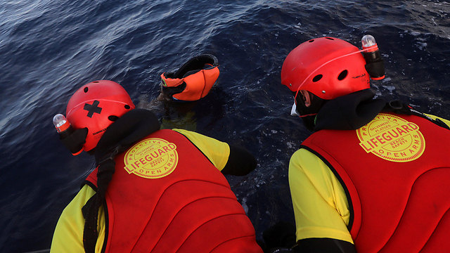Спасатели извлекают тела погибших из воды. Фото: Reuters