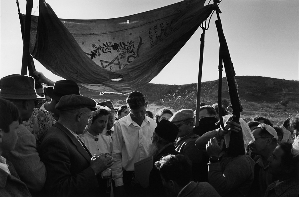 A makeshift Chuppah from 1952, held up by pitchforks and rifles (Photo: David Seymour)