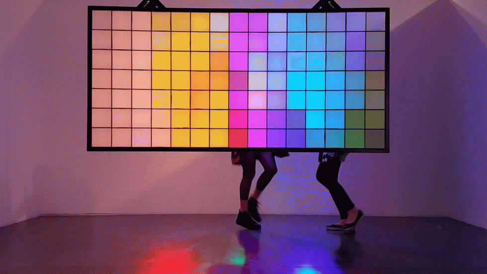 עבודתן של אירה רזניק וטליא ינובר היא העבודה השמחה ביותר בתערוכה: מסגרת מלבנית שמלאה בקוביות נייר נתלתה בחלל, והוארה מאחור בשלוש אלומות אור בצבעי יסוד. מי שעובר בין  האור לבין הקוביות מייצר צללים, ואלה מתורגמים בעזרת תכונות הנייר הלבן והפשוט לאור בגוונים זוהרים (צילום: שרון רובינס)