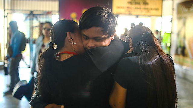 עם אמו ואחותו בנמל התעופה (צילום: AFP) (צילום: AFP)