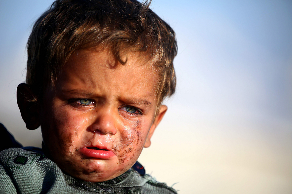 ילד סורי בוכה במחנה פליטים זמני בכפר עין עיסא, שבו גרים תושבים רבים שברחו ממעוז דאעש במדינה - העיר א-רקה (צילום: AFP) (צילום: AFP)