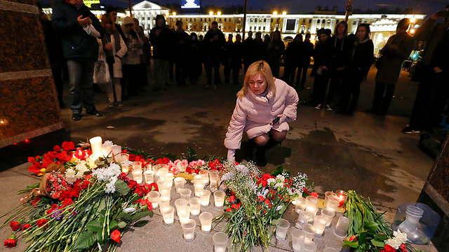 מניחים פרחים ומדליקים נרות ליד תחנת הרכבת בסנט פטרבורג שבה אירע הפיצוץ (צילום: רויטרס) (צילום: רויטרס)