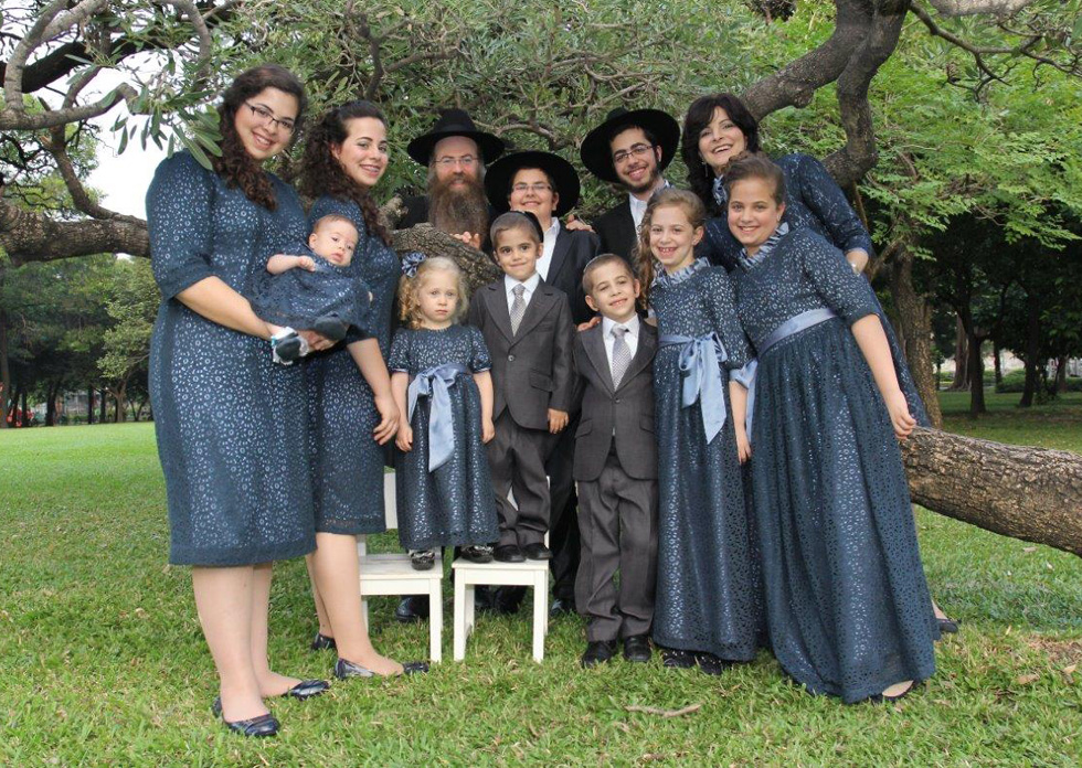 הרב וילהלם (בשורה העליונה, שלישי משמאל) עם אשתו נחמה-דינה (בשורה העליונה, ראשונה מימין) ועשרת ילדיהם (צילום: ארכיון בית חב״ד בנגקוק)