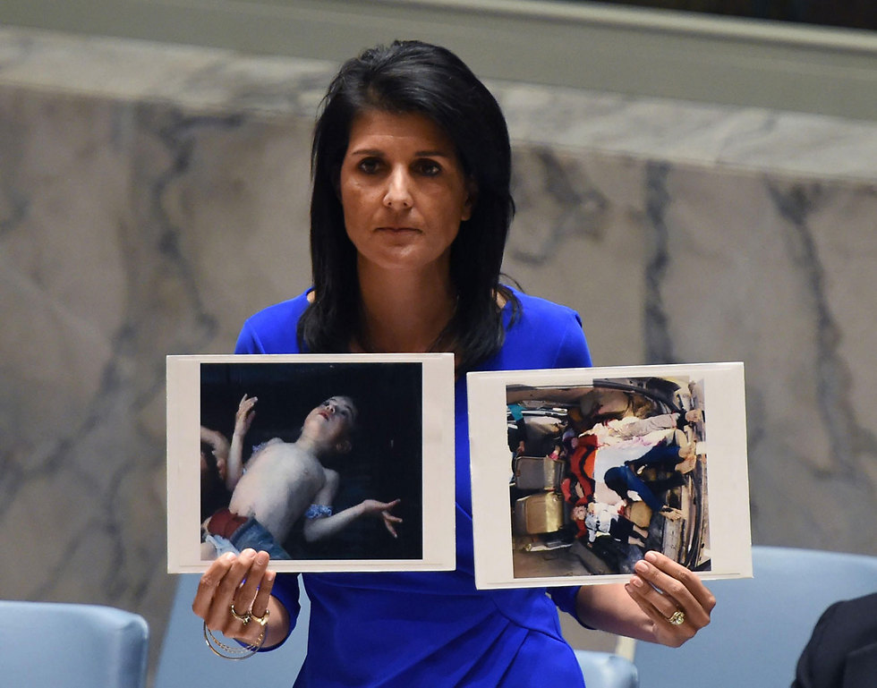 השגרירה באו"ם ניקי היילי עם תמונות של נפגעי המתקפה (צילום: AFP) (צילום: AFP)