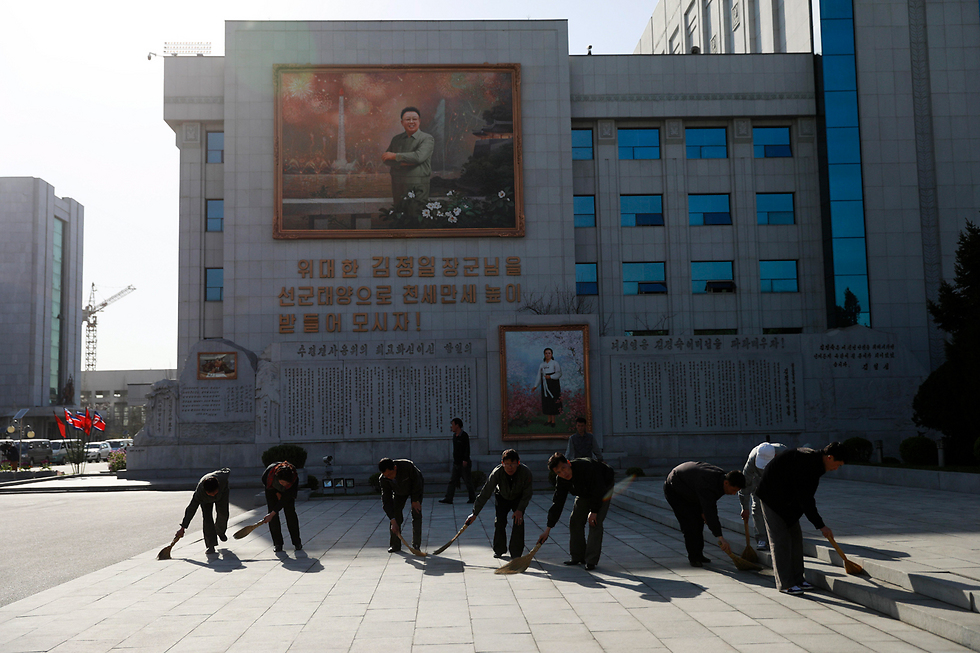 מנקים את הרחבה ליד תמונתו של קים איל סונג (צילום: EPA) (צילום: EPA)