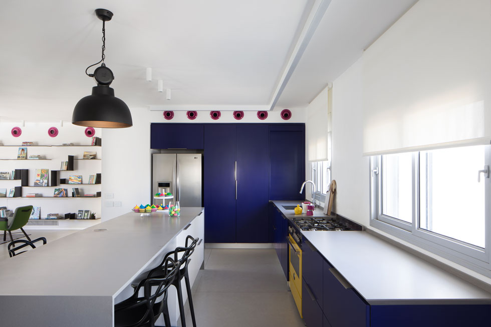 הדלתות של ארונות המטבח נצבעו בסגול כהה, שנבחר לאחר שבני הבית רכשו תנור צהוב (צילום: טל ניסים)