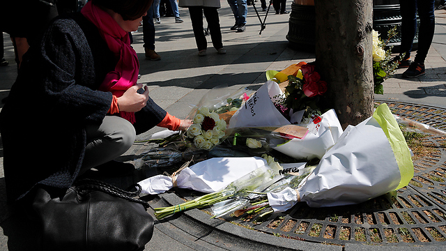 אזרחים מניחים זרי פרחים בזירת הפיגוע בשאנז אליזה (צילום: AP) (צילום: AP)