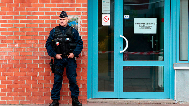 שוטר בכניסה לקלפי בצפון צרפת (צילום: AFP) (צילום: AFP)