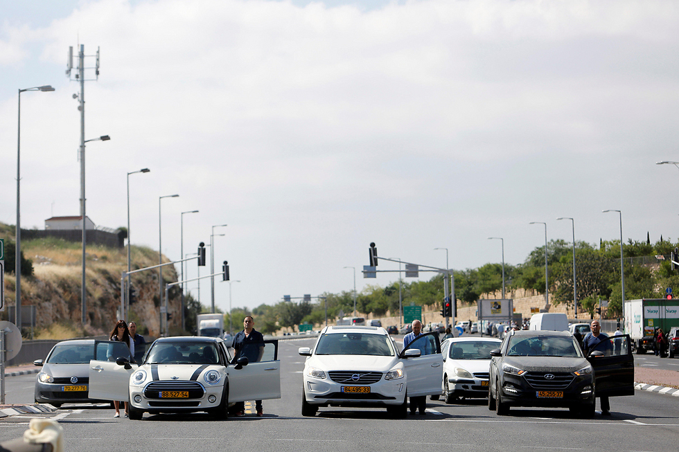 Drivers leave their cars to stand at attention during the 2-minute siren (Photo: Reuters)
