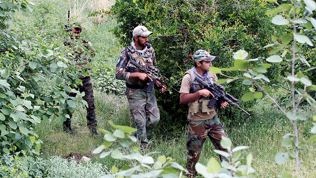 כוחות הביטחון האפגניים מסיירים ליד אתר ההפצצה (צילום: רויטרס) (צילום: רויטרס)