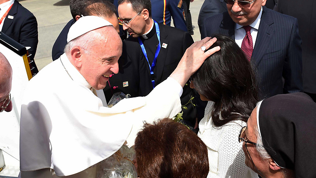 The pope blesses a woman on deplaning (Photo: EPA)