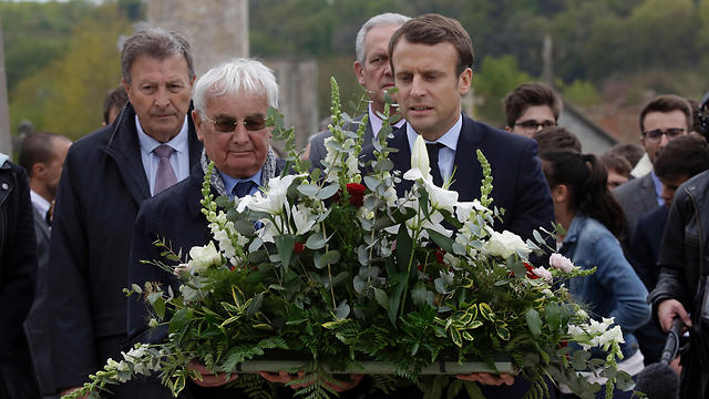 Emmanuel Macron (R) and Robert Hébras, the last living survivor of the Oradour-sur-Glane massacre, deposit a spray of flowers during a campaign visit of the ruins in the village. (Photo: AFP)